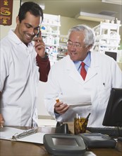 Multi-ethnic pharmacists looking at paperwork