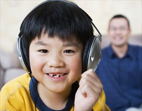 Asian boy listening to headphones