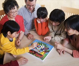 Asian family playing board game
