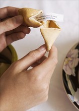 Asian girl opening fortune cookie