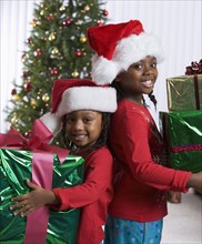 African sisters holding Christmas gifts