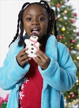African girl eating Christmas cookie