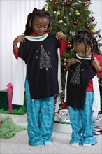 African sisters holding matching Christmas gifts