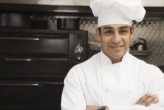 Hispanic male chef with arms crossed