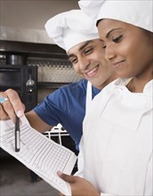 Multi-ethnic pastry chefs looking at paperwork