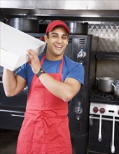 Hispanic male pizza maker holding box