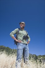 Mixed race man backpacking on hillside
