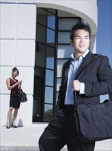 Asian businessman standing outdoors with briefcase