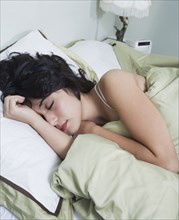 Hispanic woman sleeping in bed