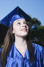 Mixed race girl in graduation cap and gown