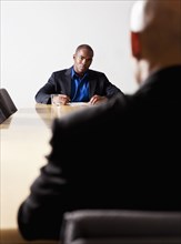 Mixed race businessmen having meeting in conference room