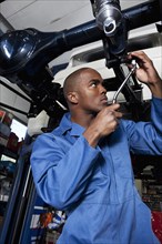 Black mechanic working on car