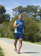 Mixed race man running on rural road