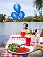 Girl holding balloons at picnic