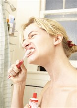 Caucasian woman brushing her teeth