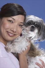 Chinese woman holding dog outdoors