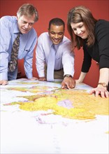 Business people examining world map