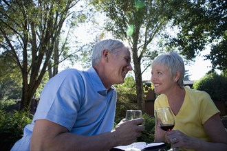 Senior Caucasian couple drinking wine outdoors