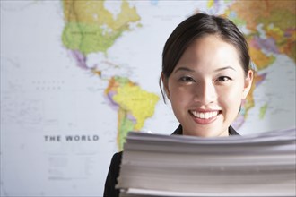 Chinese businesswoman standing by world map