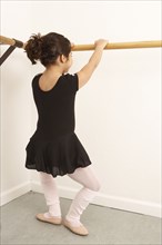 Mixed race girl practicing ballet in studio