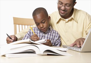 African American father helping son with homework