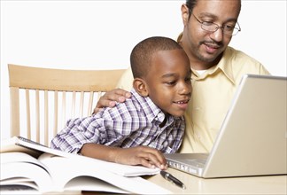 African American father helping son with homework