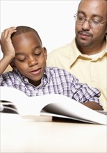 African American father helping son with homework