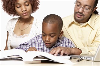 African American parents helping son with homework
