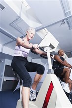 People using exercise machines in gym