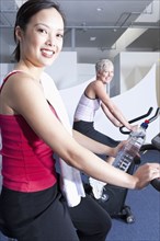 Women using exercise machines in gym