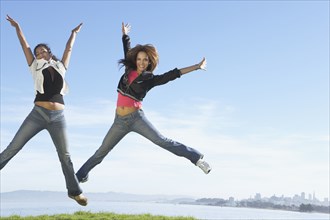 Women jumping for joy on hilltop