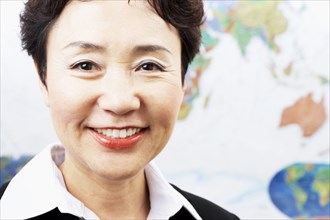 Chinese woman smiling by world map