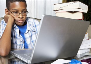Mixed race boy using laptop