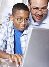 Father and son using laptop together