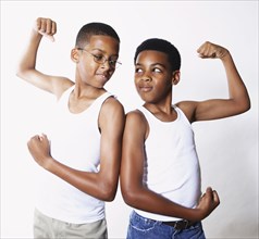 Mixed race boys flexing their muscles