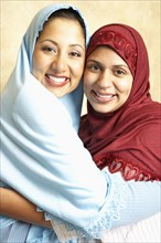 Women in headscarves hugging