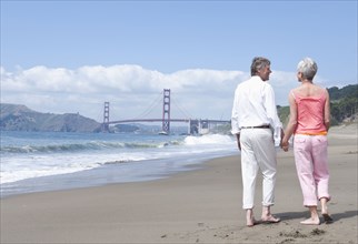 Senior Caucasian couple walking by Golden Gate Bridge