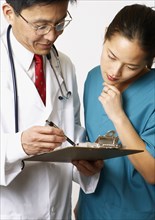 Doctor and nurse reading medical charts together