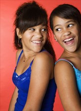 Mixed race teenage twin girls smiling
