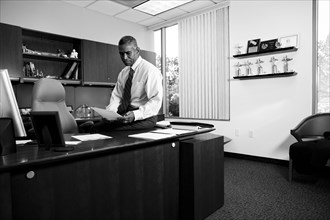 African American businessman sitting on desk