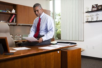 African American businessman sitting on desk