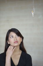 Asian woman looking at cigarette on hook