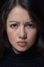 Close up of Hispanic woman furrowing brow