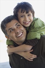 Hispanic boy hugging father