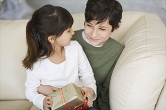 Hispanic brother and sister holding Christmas gift