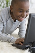 African boy typing on laptop