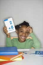 African girl holding addition flash cards