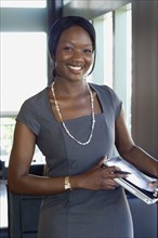 African businesswoman holding laptop