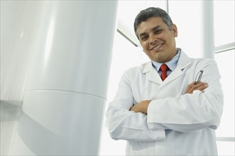 Hispanic male doctor with arms crossed