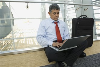Hispanic businessman typing on laptop